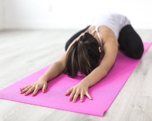 woman doing yoga stretching indoors